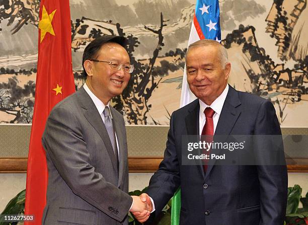 China's Foreign Minister Yang Jiechi shakes hands with Uzbekistan President Islam Karimov during their meeting at the Diaoyutai State Guesthouse on...