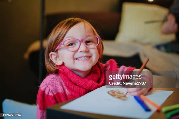 adorable little girl coloring at home - kid holding crayons stock pictures, royalty-free photos & images