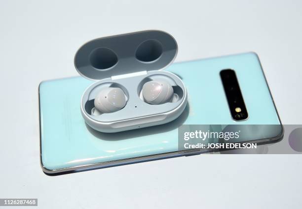 Galaxy Buds charge wirelessly atop an S10 phone during the Samsung Unpacked product launch event in San Francisco, California on February 20, 2019. -...