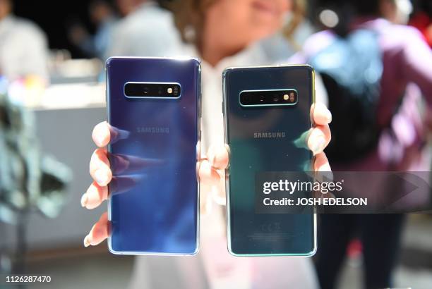Samsung employee displays an S10+ and an S10 phone during the Samsung Unpacked product launch event in San Francisco, California on February 20,...