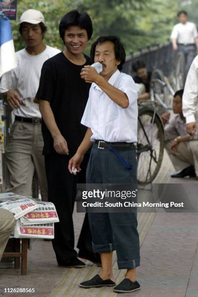 Pedicab driver Mr Zhang Yinlu who is 1.5metres tall waits for customers near the Jianguomenwai subway station in Beijing, China. Size descrimination...
