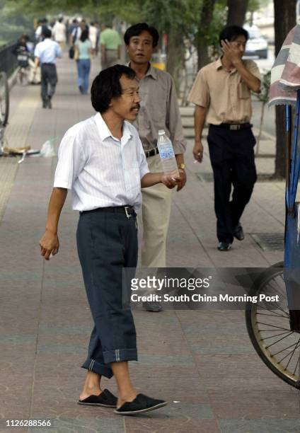 Pedicab driver Mr Zhang Yinlu who is 1.5 metres tall waits for customers near the Jianguomenwai subway station in Beijing, China. Size descrimination...