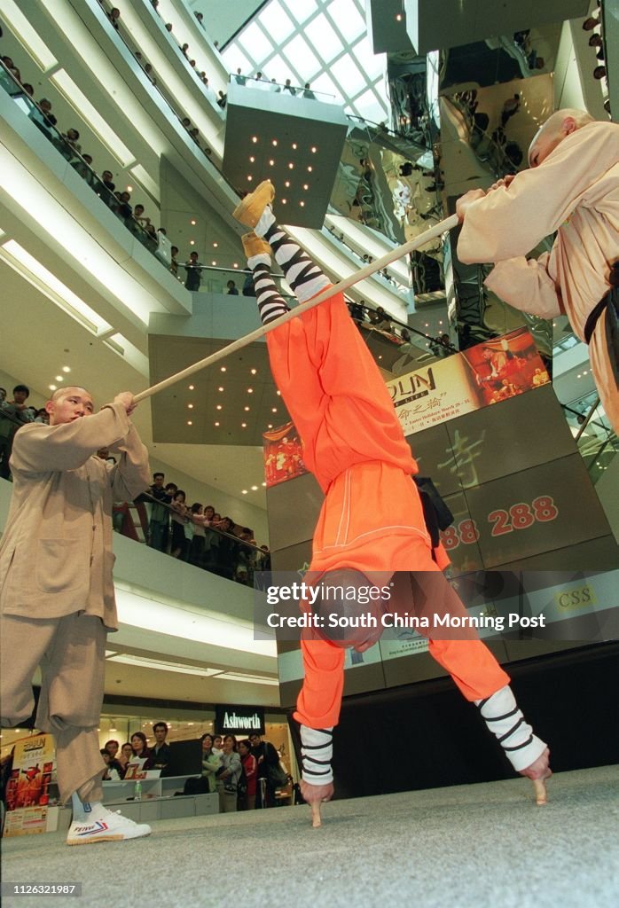 Shi Yanbao, 25, one of the Shaolin monks who will perform in a stage production called "Shaolin-Wheel of Life", shows his kung-fu techniques by standing upside down on two fingers in a promotional function at Festival Walk , Kowloon Tong.