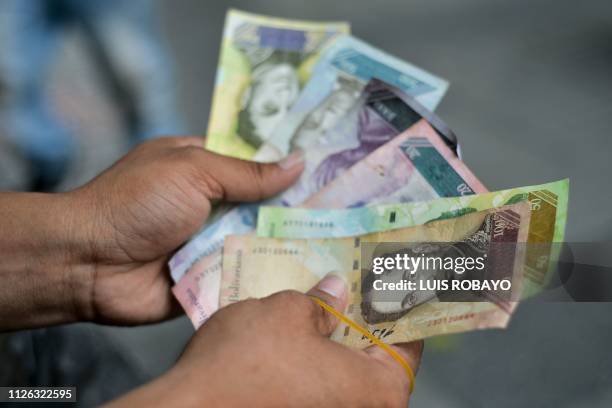 Man shows Bolivar bills he will use to make handicrafts in a street of Cucuta, Colombia, on the border with Venezuela, on February 20, 2019. The...