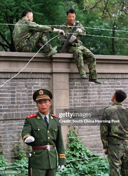 Soldiers erect a barbed wire fence around the Cuban Embassy in the Jianguomenwai Embassy area of Beijing,China. All embassies in the city are...