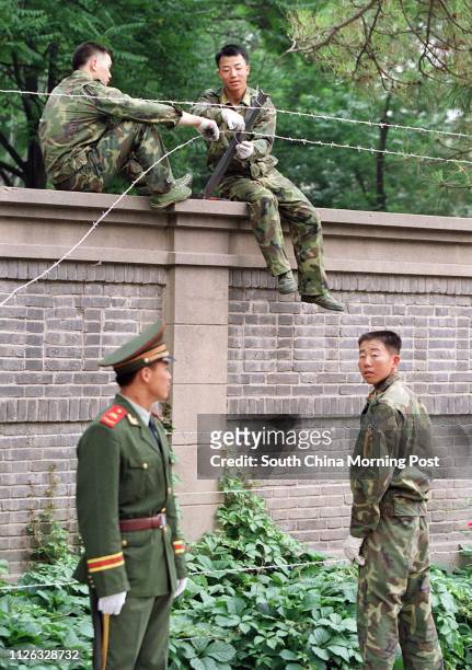 Soldiers erect a barbed wire fence around the Cuban Embassy in the Jianguomenwai Embassy area of Beijing,China. All embassies in the city are...