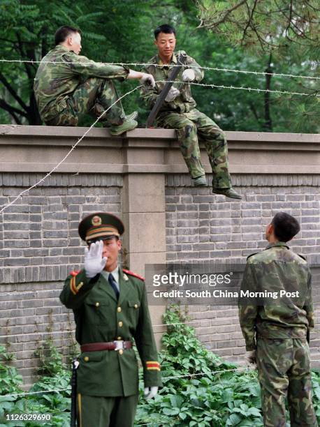 Soldiers erect a barbed wire fence around the Cuban Embassy in the Jianguomenwai Embassy area of Beijing , China. All embassies in the city are...