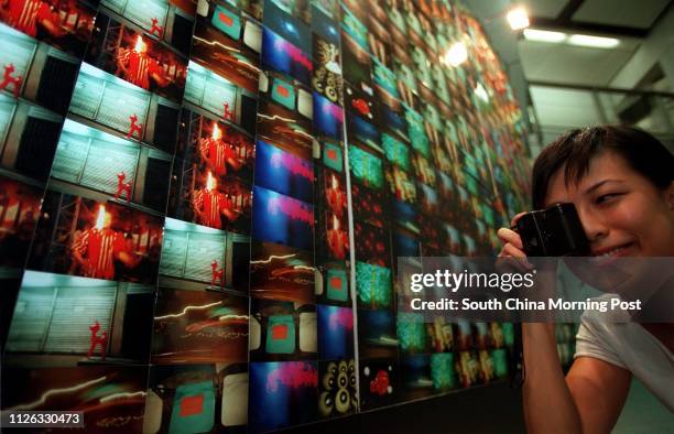 Tweedy Leung Yin-sheung, a keen photographer, poses with her Lomo camera during a competition/exhibition that has been displayed in the Central MTR...