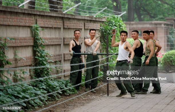 Soldiers erect a barbed wire fence around the Indian Embassy in the Jianguomenwai Embassy area of Beijing,China. All embassies in the city are...