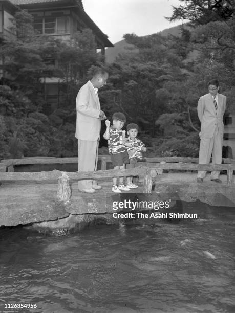 Prime Minister Nobusuke Kishi strolls with son-in-law Shintaro Abe , grandsons Hironobu and Shinzo on July 7, 1957 in Hakone, Kanagawa, Japan.