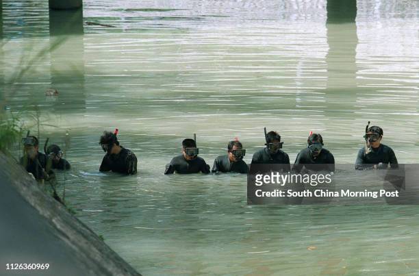 Special Duties Unit officers search the 1.2 metre deep water in the Lam Tsuen River, Tai Po 2 Nov 95, for the remaining body parts of a dead woman,...