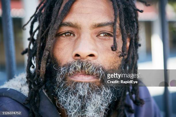 sad homeless person with rastafarian dreadlocks - rastafarian stock pictures, royalty-free photos & images
