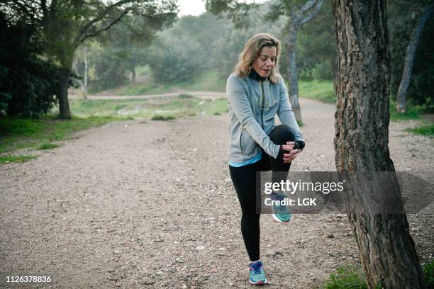 woman exercises early morning in a park - läufer dramatisch stock-fotos und bilder