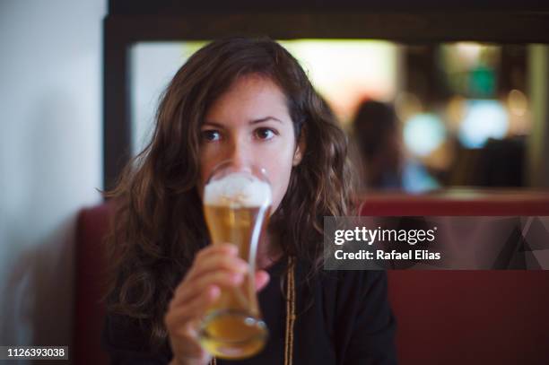 serious young woman drinking beer - sans alcool photos et images de collection