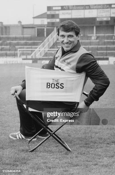 English football player, manager, pundit and chairman of Watford Football Club Graham Taylor sitting on a chair which says 'The Boss', at Vicarage...