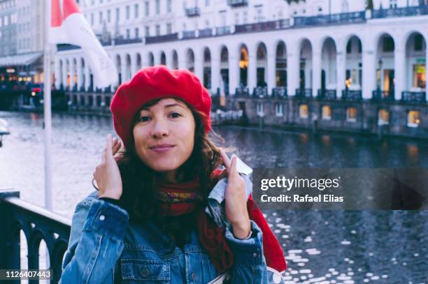 pretty happy young woman with red beret by city canal - basker bildbanksfoton och bilder