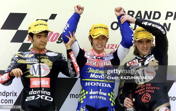 Japanese champion Daijiro Kato of Telefonica Movister Honda celebrates with his rivals, Japanese Tetsuya Harada of MS Aprilia Racing and Italian...