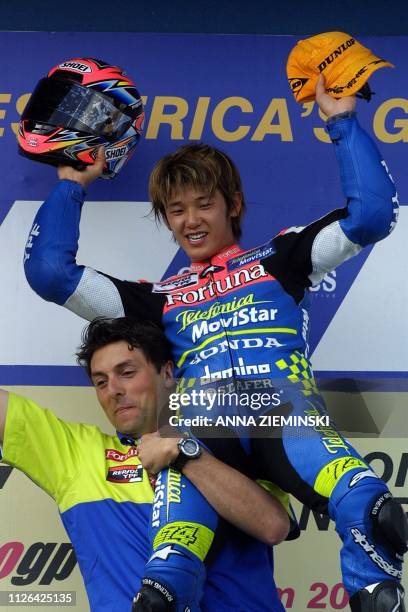 Japanese Daijiro Kato is held aloft by an unidentified person 22 April 2001 after winning the 250cc class race in the second leg of the South African...