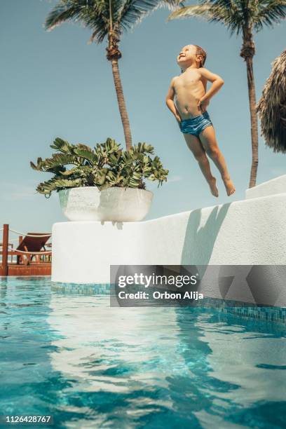 jongen springen in het zwembad - jump in pool stockfoto's en -beelden