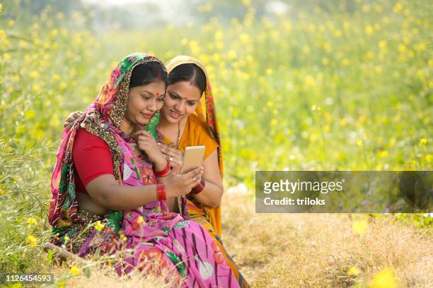 rural women using mobile phone in agricultural field - village stock pictures, royalty-free photos & images