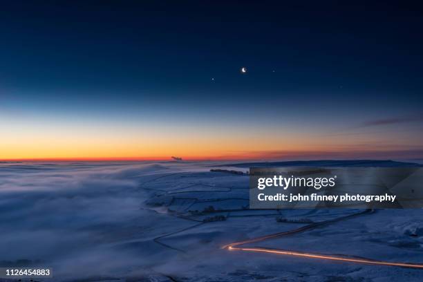 jupiter, venus, moon conjunction over freezing fog and snow. peak district. uk - 金星 ストックフォトと画像