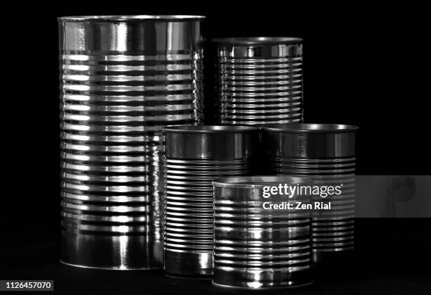 stack of tin- steel- aluminum cans without labels against black background - estaño fotografías e imágenes de stock