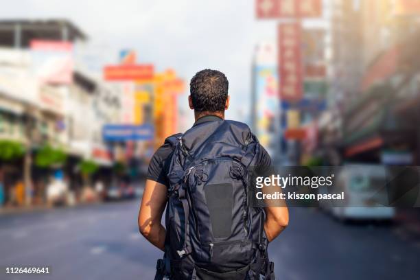 tourist backpacker walking in the chinatown of bangkok during day , thailand - hinterkopf stock-fotos und bilder