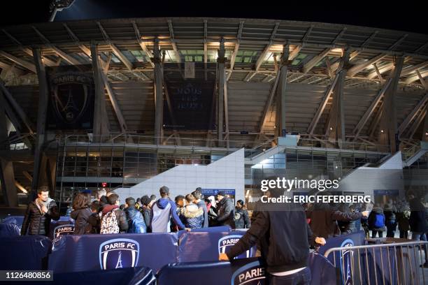 Football fans arrive to watch the French L2 football match between FC Paris and Ajaccio at the Charlety Stadium on February 15, 2019 in Paris.