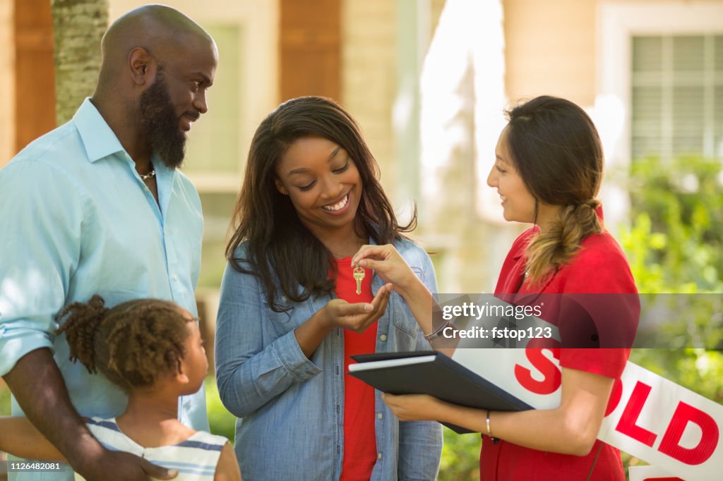 Real Estate Agent and family looking at new home to purchase.