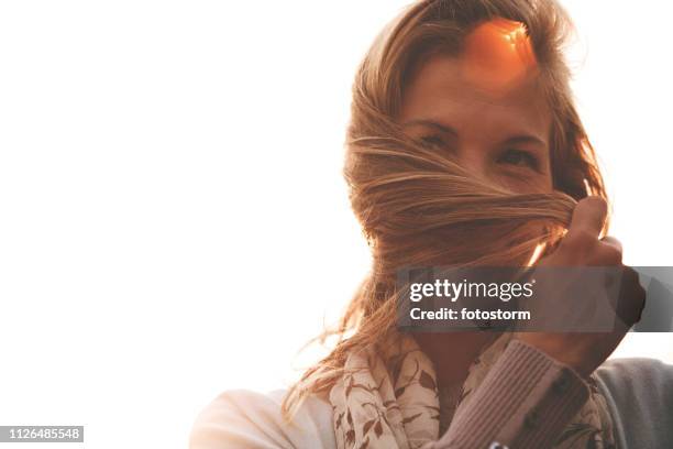 joyful woman holding hair outdoors - touching hair stock pictures, royalty-free photos & images