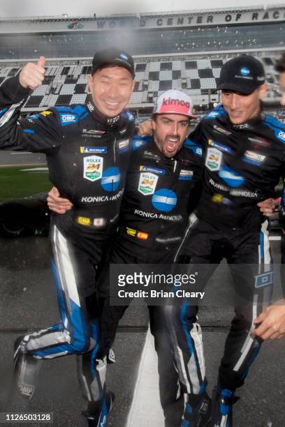 Left to Right, Kamui Kobayashi, of Japan, Fernando Alonso, of Spain, and Renger van der Zande, of the Netherlands, celebrate in the rain after...