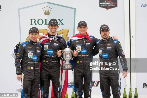 Left to Right, Kamui Kobayashi, of Japan, Jordan Taylor, Renger van der Zande, of the Netherlands, and Fernando Alonso, of Spain, celebrate in...