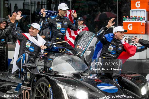 Fernando Alonso, of Spain, drive his car into Victory Lane as teammates Kamui Kobayashi, of Japan, Jordan Taylor, and Renger van der Zande, of the...