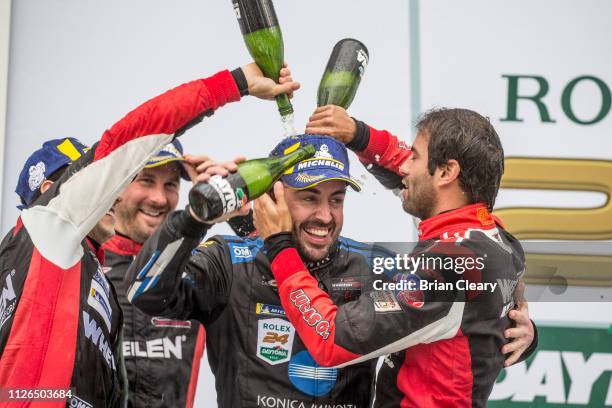 Fernando Alonso, of Spain, is doused with champagne by rival drivers after winning the Rolex 24 at Daytona, Daytona International Speedway, Daytona...