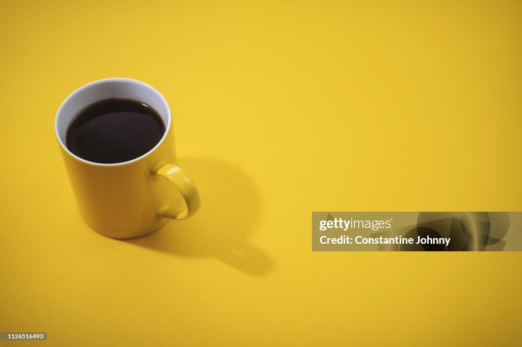 Yellow Coffee Mug on Yellow Background.