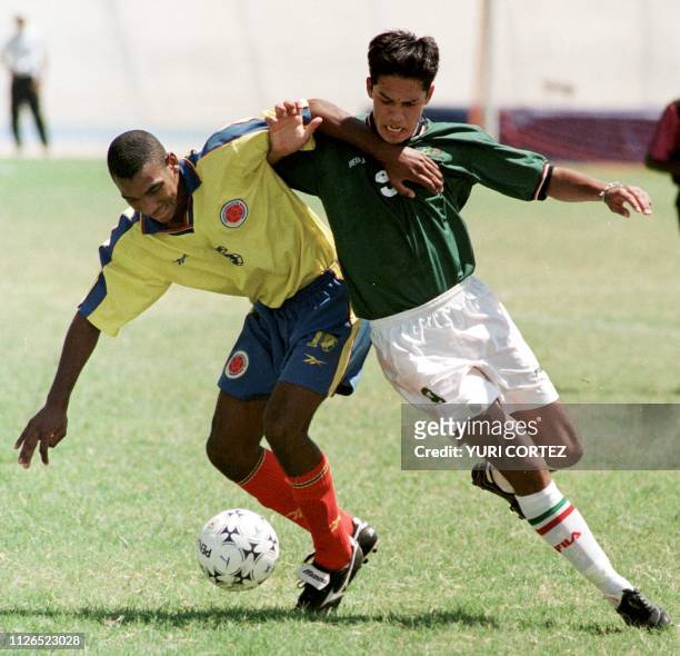 Mauricio Tamayo of Colombia fights for the ball with Eduardo Lillingston from Mexico 17 August during a soccer game in the Pachencho Romero Stadium...