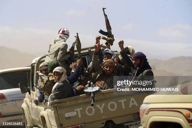 Armed Yemeni men raise their weapons as they gather near the capital Sanaa to show their support to the Shiite Huthi movement against the Saudi-led...