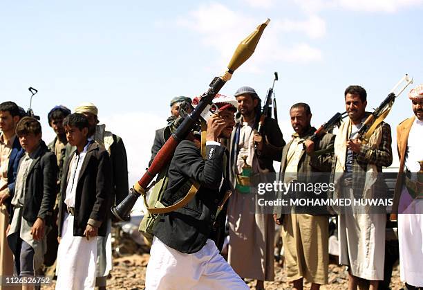Yemeni man carries a rocket-propelled grenade launcher as he takes part in a gathering near the capital Sanaa to show support to the Shiite Huthi...