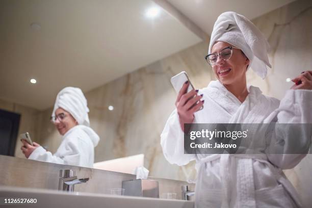 woman brushing her teeth in bathroom - brush teeth phone stock pictures, royalty-free photos & images
