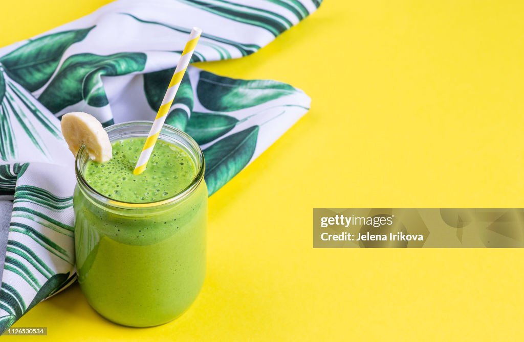 Frullati di spinaci verdi in barattolo con semi di chia, concetto di cibo sano, colazione, sfondo giallo
