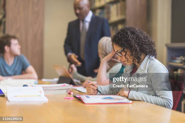 college students studying in the library - masters degree imagens e fotografias de stock