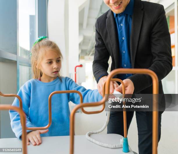 the little girl exploring electricity in the hall of science together with her older brother, young man - science museum stock pictures, royalty-free photos & images
