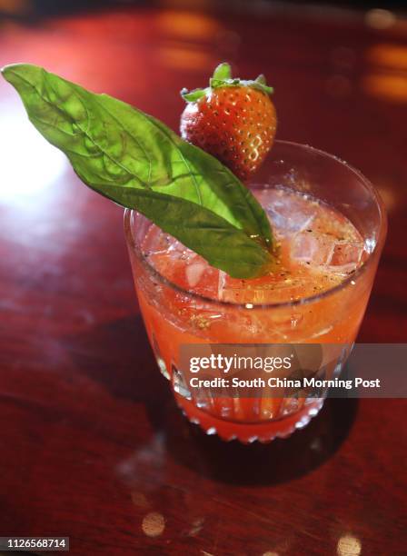 Basil Grande - a unique combination of vodka, cherry liquor, grand marnier, and cranberry juice finished with basil and strawberries, at Tiffany's...