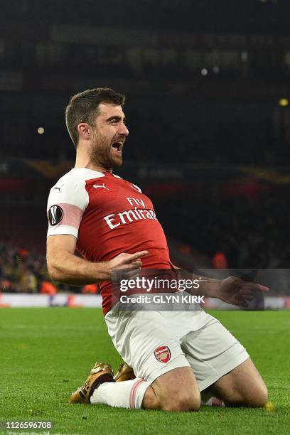 Arsenal's Greek defender Sokratis Papastathopoulos celebrates after scoring their third goal during the UEFA Europa League round of 32, 2nd leg...