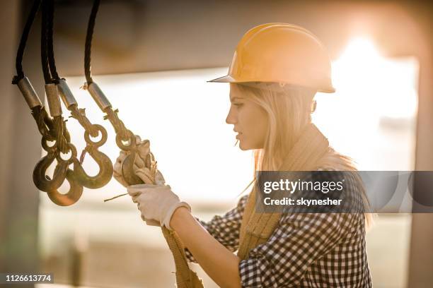 weibliche arbeiter arbeiten mit seilwinde auf einer terrasse. - kabelwinden stock-fotos und bilder