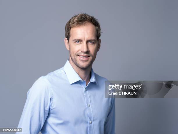 portrait d’homme d’affaires souriant sur le fond gris - chemise homme photos et images de collection