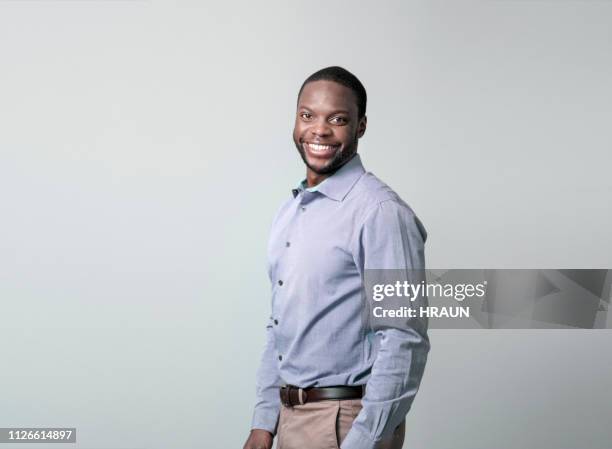 jonge zakenman lachend over grijze achtergrond - black shirt stockfoto's en -beelden