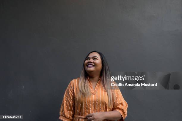 young mixed race woman smiling on solid background - capelli in due diverse tonalità foto e immagini stock