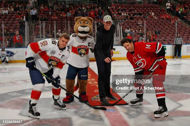 Tennis Professional John Isner participates in the ceremonial puck drop with Aleksander Barkov of the Florida Panthers and Justin Williams of the...