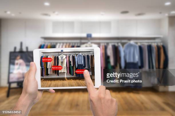 augmented reality marketing concept. hand holding digital tablet smart phone use ar application to check special sale price in retail fashion shop mall - smart fashion stock-fotos und bilder